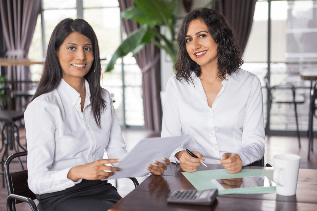 two-happy-female-colleagues-working-with-documents-cafe